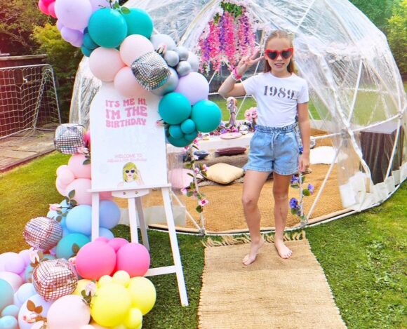 Taylor Swift themed birthday party with balloon arch outside igloo